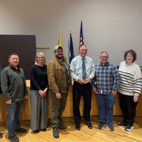 Jim Thares holding 2025 Partner of the Year Award with City Council and staff.